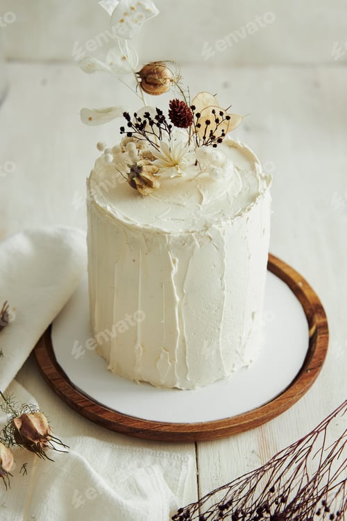 Preview: Top view of delicious Boho ombre cake with dry flowers on a white table