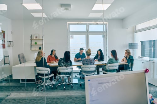 Preview: Diverse Business Team Discussing Projects in a Modern Glass Office.