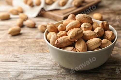 Preview: Pecan nuts in bowl on wooden table, space for text