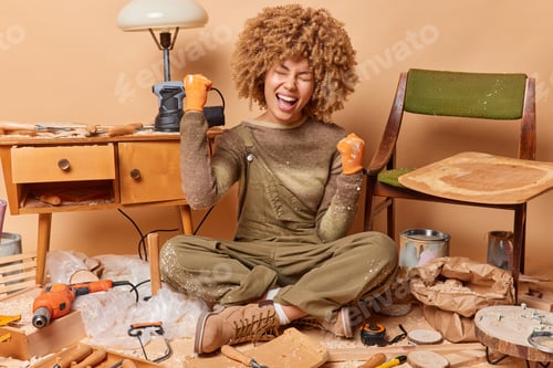 Preview: Photo of cheerful smiling satisfied African american woman sitting on floor of handicraft workshop