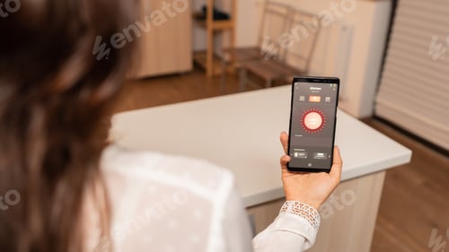 Preview: Woman in home kitchen using phone app to remotely control lighting system