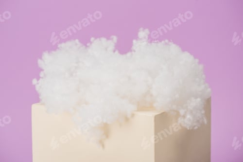 Preview: white fluffy cloud made of cotton wool on cube isolated on violet background