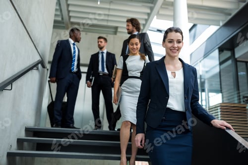 Preview: Confident businesswoman with colleagues climbing down the stairs