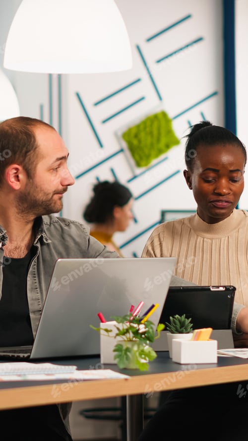 Preview: Team of diverse startup colleagues sharing ideas over financial strategy management
