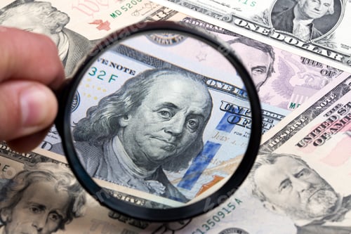 Preview: American dollars in a magnifying glass