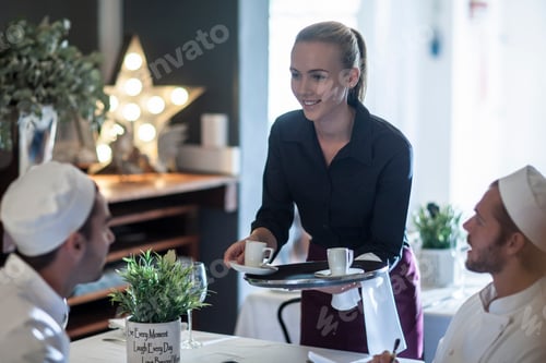 Preview: Waitress serving coffee to chefs at break time