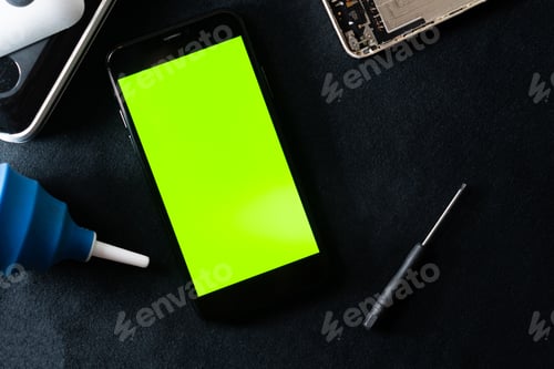 Preview: Smart phone with Green Screen in Tech Workspace