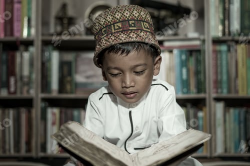 Preview: Smart school Asian boy reading an antique book at the Pedir Museum Aceh