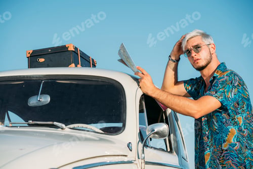 Preview: Man with map looking away near car