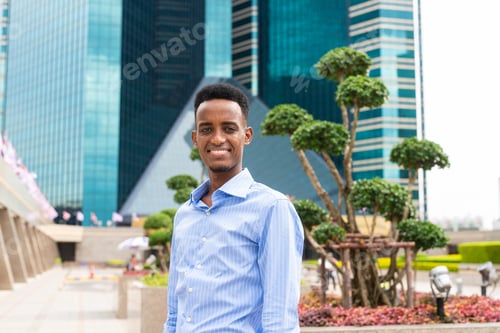 Preview: Portrait of handsome young black man outdoors in city