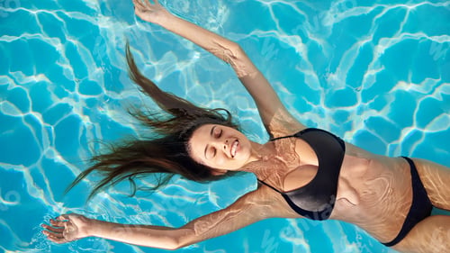 Preview: Summerthe time to feel alive. Shot of a young woman in a swimming pool.