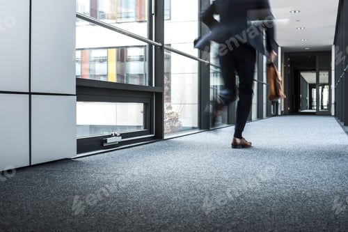 Preview: Businessman running in corridor of an office building