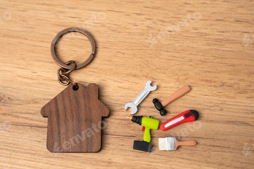 Preview: Figurine of a house and repair tools: spanner, brushes, hammer, stationery knife, plasterer.