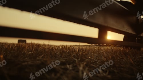 Preview: Farmer boots walking wheat field machinery at golden sunset. Rural view concept.