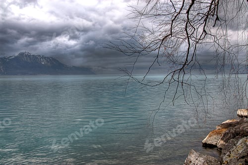 Preview: Scenic view of a tranquil lake with snow-capped mountains in the background