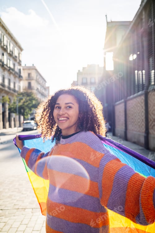 Preview: Ethnic woman on street with rainbow flag