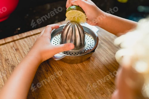Preview: Child squeezing the juice of a lemon.