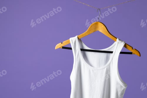Preview: Tshirt hanging on coat hanger and copy space on purple background