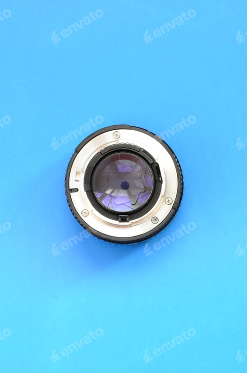 Preview: One photographic lense lie on a bright blue background. Space for text