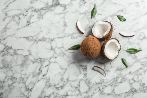 Preview: Flat lay composition with coconuts a on marble table. Space for text