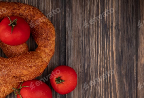 Preview: top view of tasty turkish bagels with fresh red tomatoes isolated on a wooden background with copy