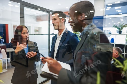 Preview: Multiracial colleagues working inside business office with glass walls