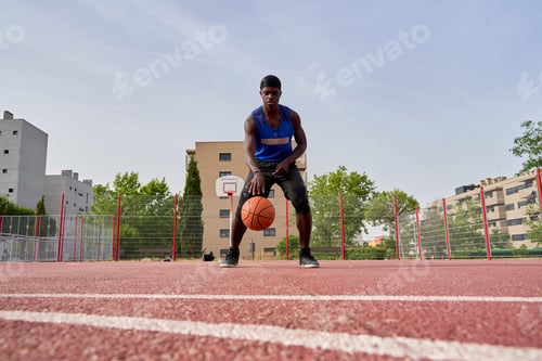 Preview: A man in a blue shirt is playing basketball on a court. He is holding a basketball in his hand
