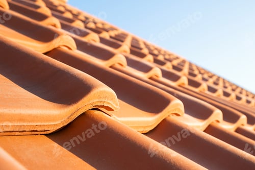 Preview: Overlapping rows of yellow ceramic roofing tiles covering residential building roof