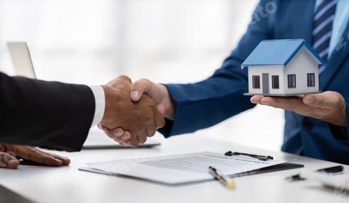Preview: Businessman shakes hands with real estate agent after reaching agreement on house purchase.