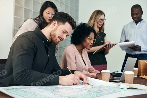 Preview: Smiling young architect at work with colleagues in an office