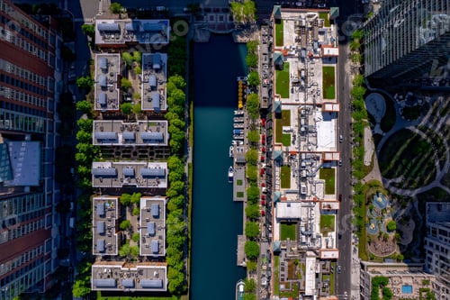 Preview: Bird's eye view of the building roofs and river surrounded by green vegetation.