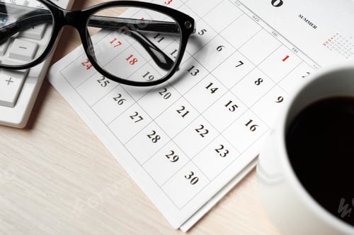 Preview: Desk setup with glasses, calendar, calculator, and coffee cup in September