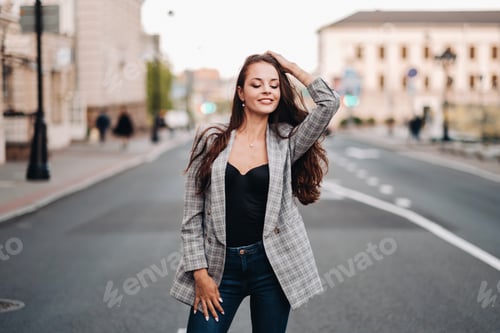 Preview: a girl in a jacket and long hair walks through the old city.A beautiful girl smiles.Girl on the road