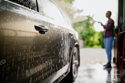 Preview: Woman washes off foam from the car, hand auto wash