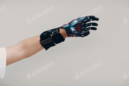 Preview: Disabled man with artificial prosthetic hand close up hand against gray background.