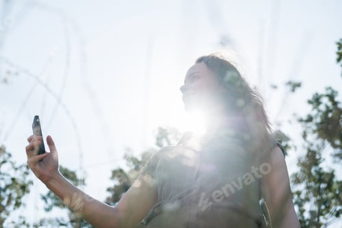 Preview: Portrait of a young millenial woman makes a selfie outside in forest