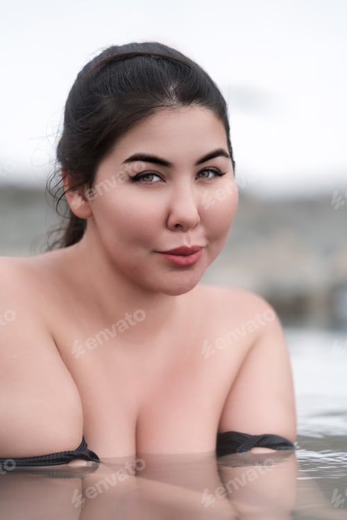 Preview: Portrait of plus size woman with big breast bathing and relaxation in water of outdoor pool at spa