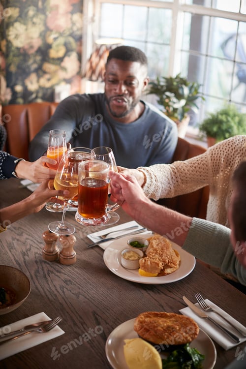 Preview: Friends Meeting For Meal In Traditional English Pub Making Toast Together