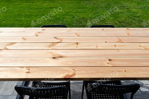 Preview: A modern table made of raw wood covered with yacht varnish, standing on the garden terrace.