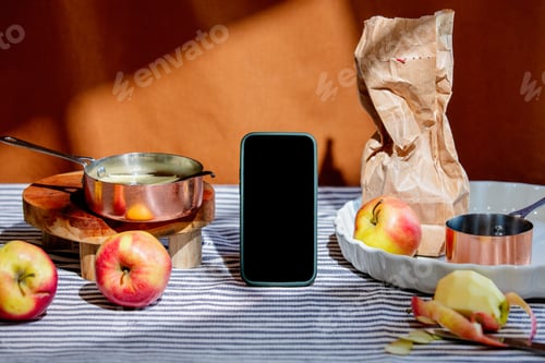 Preview: Apples, pan and mobile phone on a table. Still life