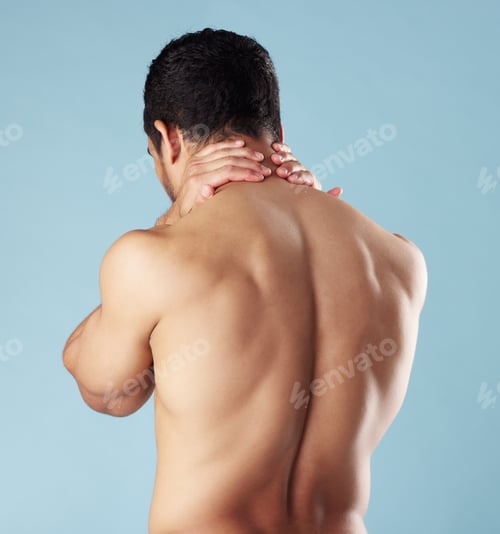 Preview: Rearview young mixed race man standing shirtless in studio isolated against a blue background. Unre