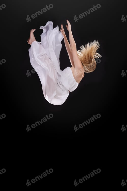 Preview: Studio shot of a woman falling upside down against a black background