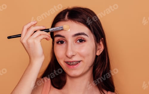 Preview: A female teenager puts a moisturizing mask or cream on her face