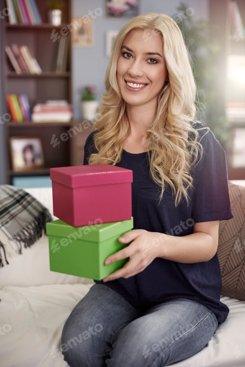 Preview: Blonde woman holding colorful boxes