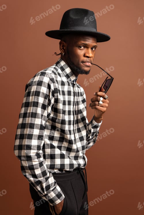 Preview: Trendy ethnic man in sunglasses on floor