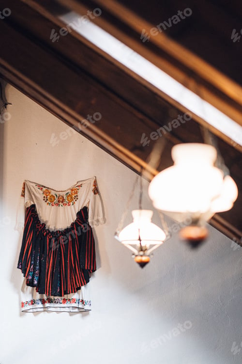 Preview: Unique hanging cloth, light fixture, and table lamp in a modern white room.