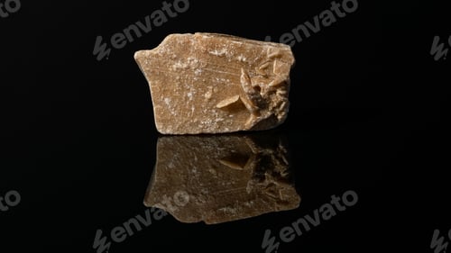 Preview: Closeup of a brown quartzite stone isolated on a black background