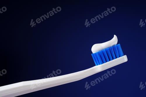 Preview: White toothbrush with toothpaste on a dark blue background. Dental king concept. Hygiene.