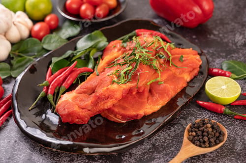 Preview: Marinated pork used in cooking, complete with chili peppers Kaffir lime leaves in a black plate