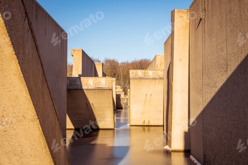 Preview: Concrete Structure Reflecting in Water Under a Blue Sky